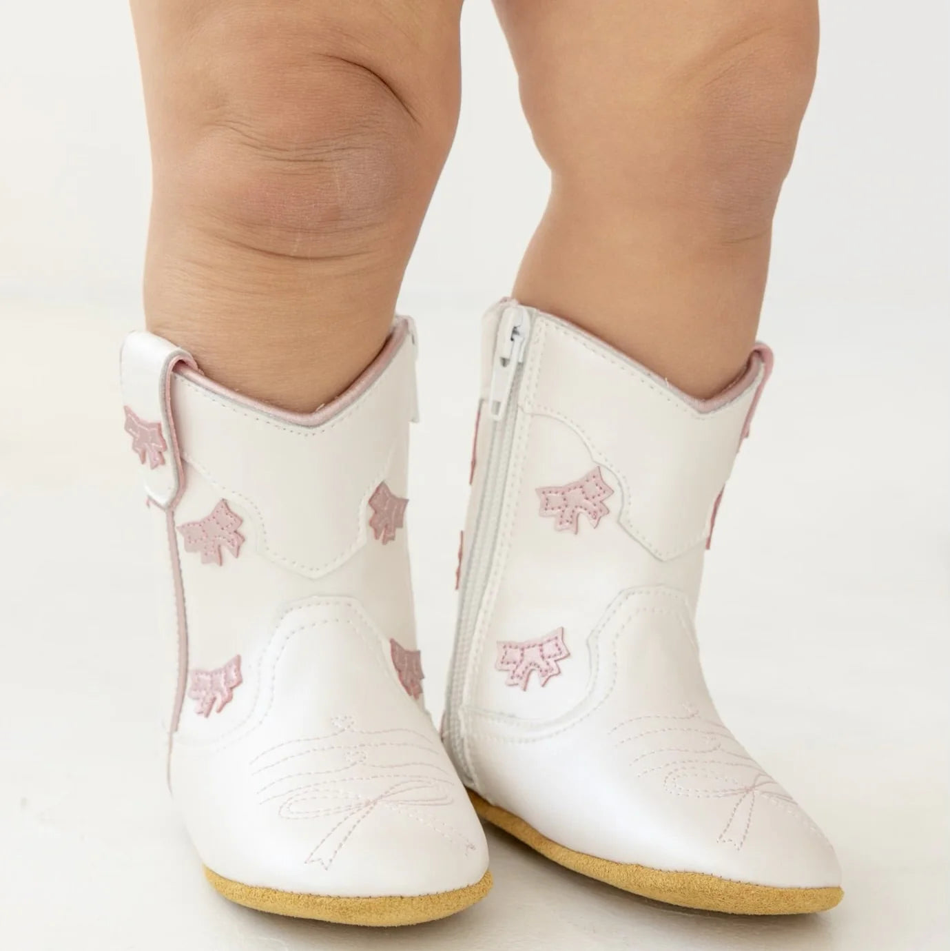 White boots with pink floral patterns on a light background
