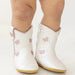 White boots with pink floral patterns on a light background