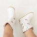 White baby booties with pink crowns on a light background