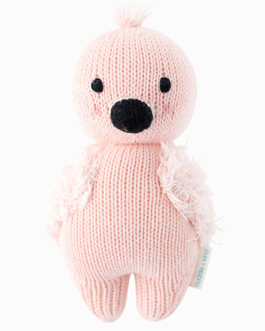 Knitted pink bear toy with black nose on a white background
