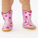 Pink cowboy boots with heart patterns on a white background