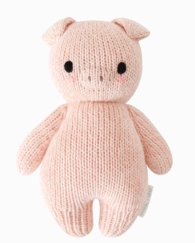 Knitted pink pig toy on a white background