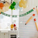 Decorative setup with 'Back to School' banner, balloons, and stationery items in a kitchen.