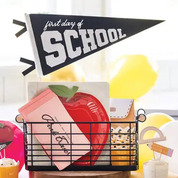 Decorative setup for the 'first day of school' with a banner, apple, and basket.