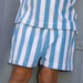 Blue and white striped shorts worn by a person against a gray background