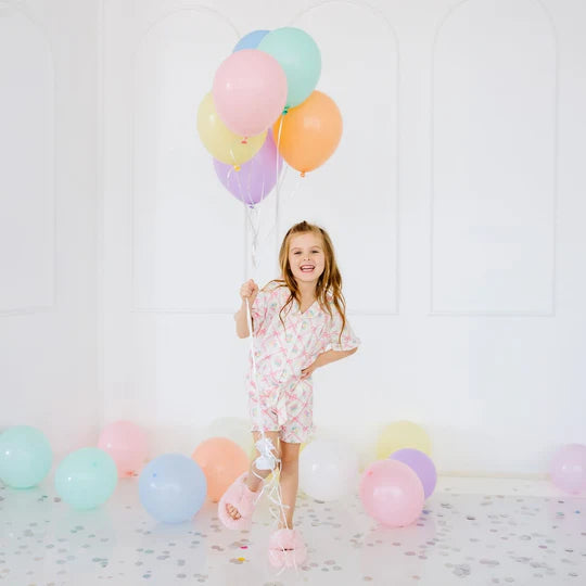 Young girl holding colorful balloons against a white background