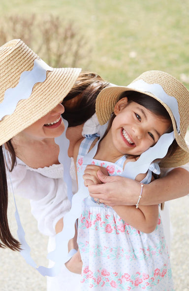 Woman and young girl wearing straw hats in a field