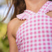 Close-up of a pink and white checkered dress with ruffled straps.