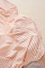 Close-up of a orange and white striped fabric with a beige background