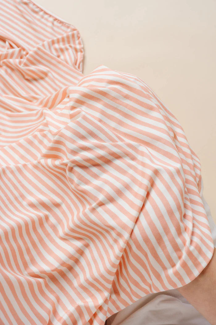Close-up of a orange and white striped fabric with a beige background