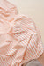 Close-up of a orange and white striped fabric with a beige background
