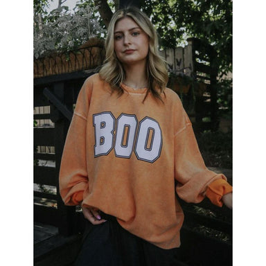 orange corded sweatshirt with white graphic "BOO"
