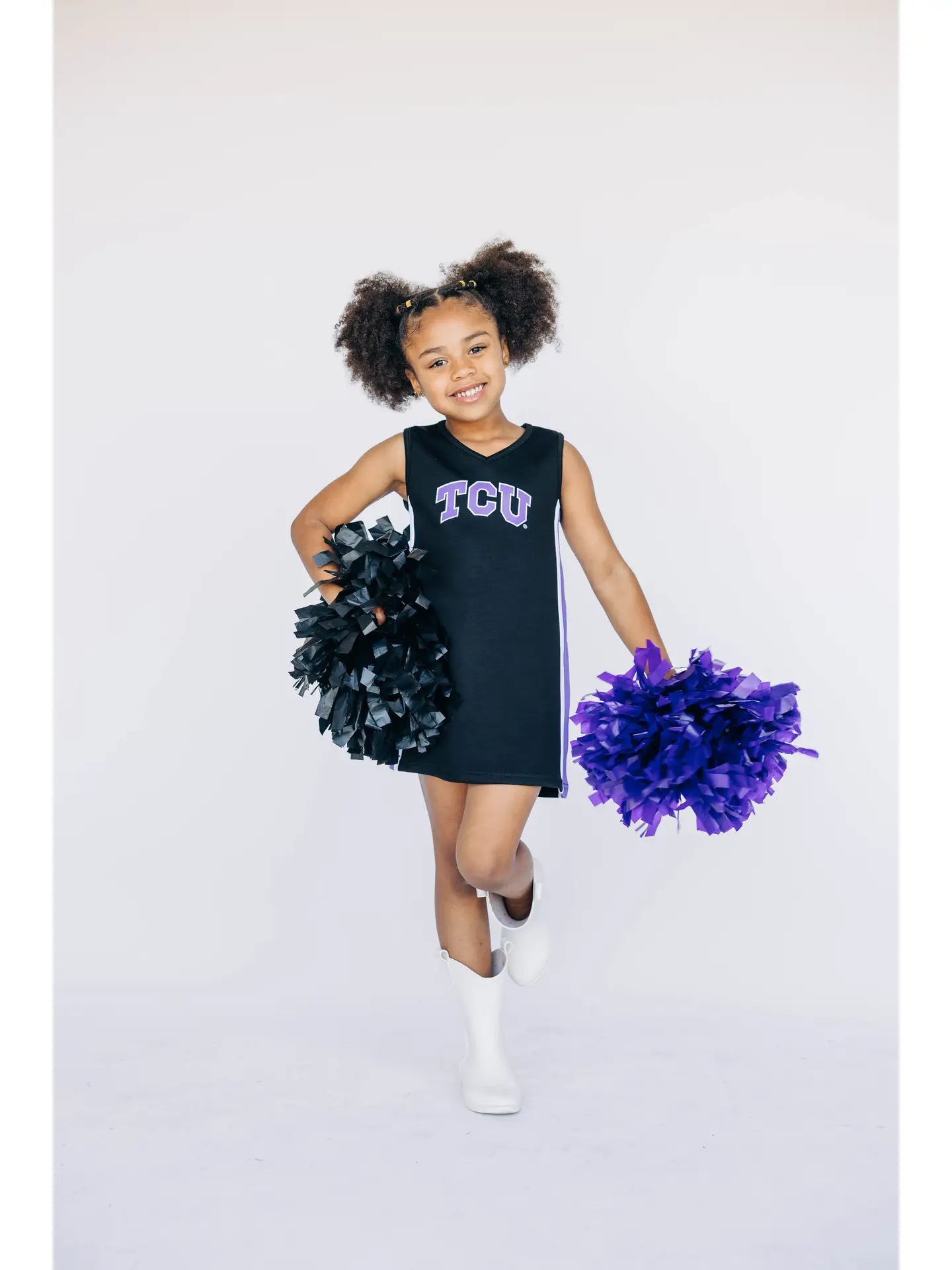 Child in TCU cheerleading outfit with pom-poms on a white background