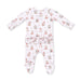 A baby long-sleeve footed sleeper in white with a repeating teddy bear print in muted red, blue, and beige, featuring a ruffled waistband.
