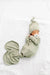 Newborn baby wrapped in a green swaddle with matching hat on a white background