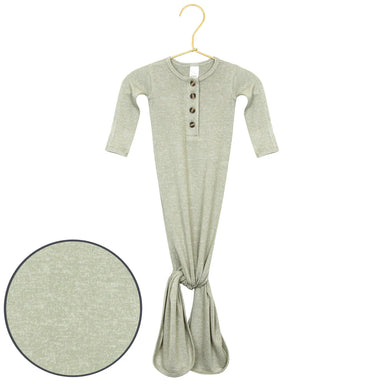 Green baby onesie with buttons on a hanger against a white background