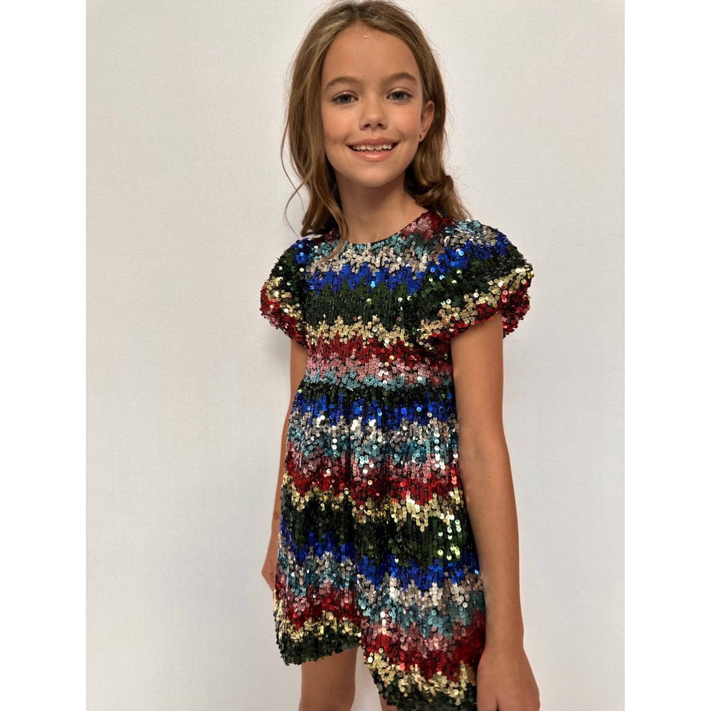 girl wearing short sleeved dress covered in holiday colored sequins