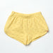 Yellow shorts with smiley face pattern on a light gray background