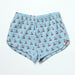 Light blue shorts with cherry pattern on a white background