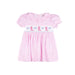 A pink gingham baby dress with short puff sleeves, a ruffled collar, and smocked details across the chest featuring pink cowboy boots and blue bows on a white band.