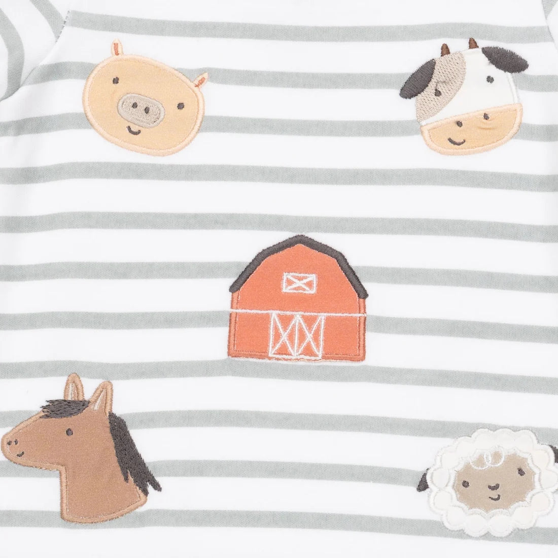 Close-up of a baby garment with horizontal gray and white stripes and embroidered farm-themed motifs including a pig, cow, barn, horse, and sheep.