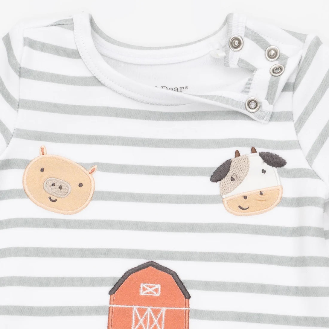 A close-up of a baby long-sleeve shirt with gray and white horizontal stripes, featuring embroidered farm animal faces (a pig and a cow) and part of an orange barn on the front.