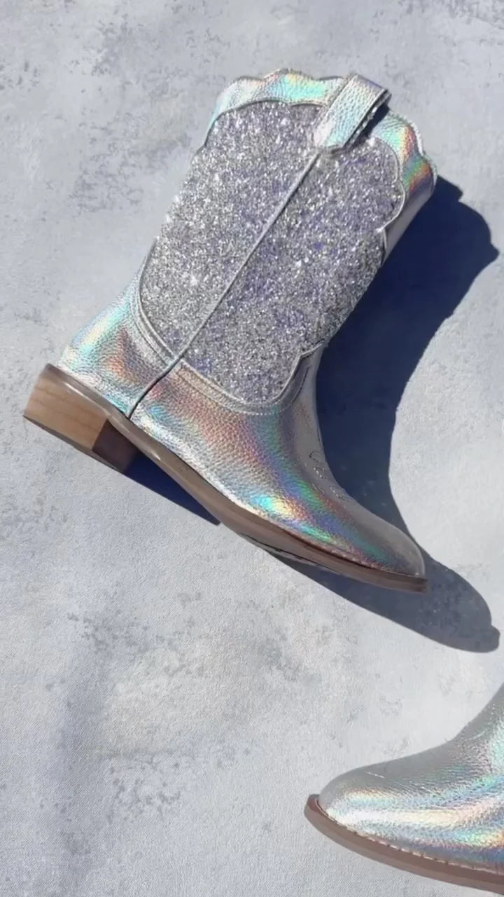 Holographic glittery boot on a concrete surface