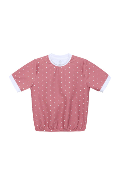 A short-sleeve top in dusty pink with a white polka dot pattern and contrasting white ribbed collar and sleeve cuffs, shown flat on a white background.