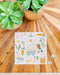 Jigsaw puzzle with nature-themed design on a wooden surface with plants.