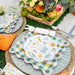 Easter-themed table setting with decorative plates, bunny napkins, and a floral centerpiece.