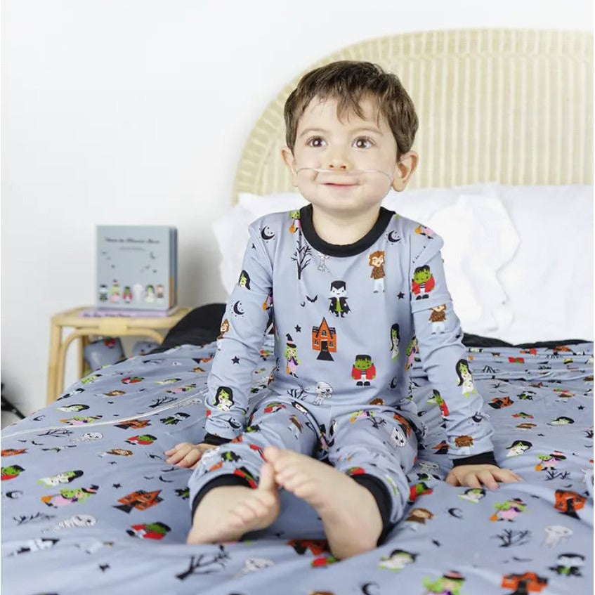 boy wearing long sleeve grey pajama set with cute "monster mash" print