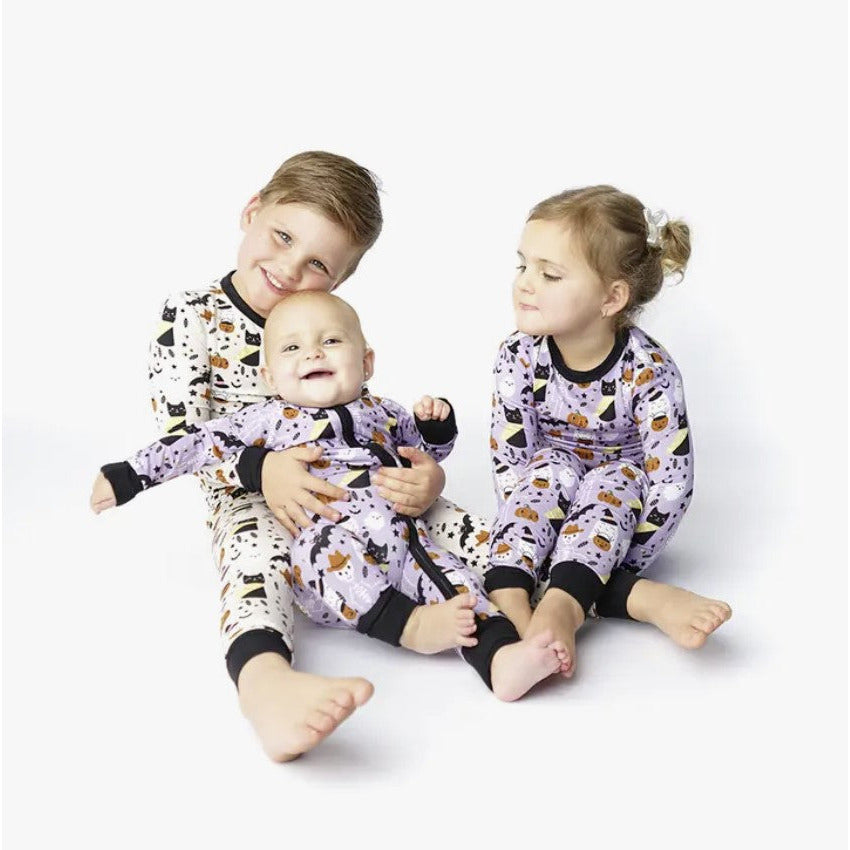 kids wearing purple spooky cute pattern with ghosts, skeleteons, cats and bats