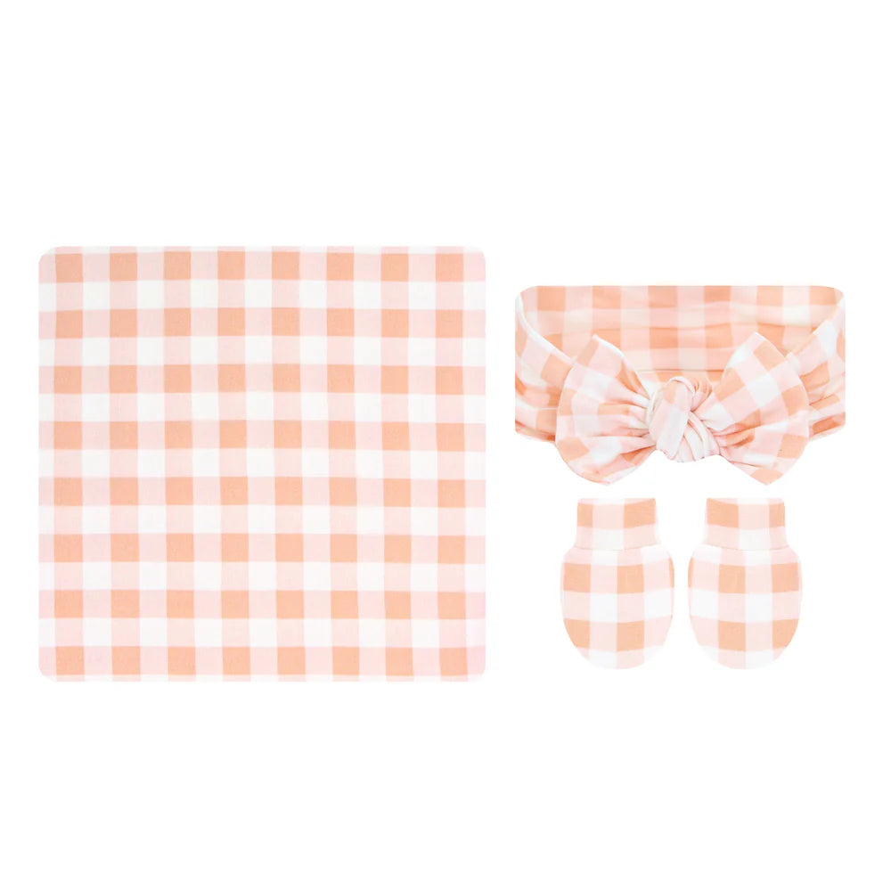 Baby accessory set with checkered blanket, headband, and booties on a white background