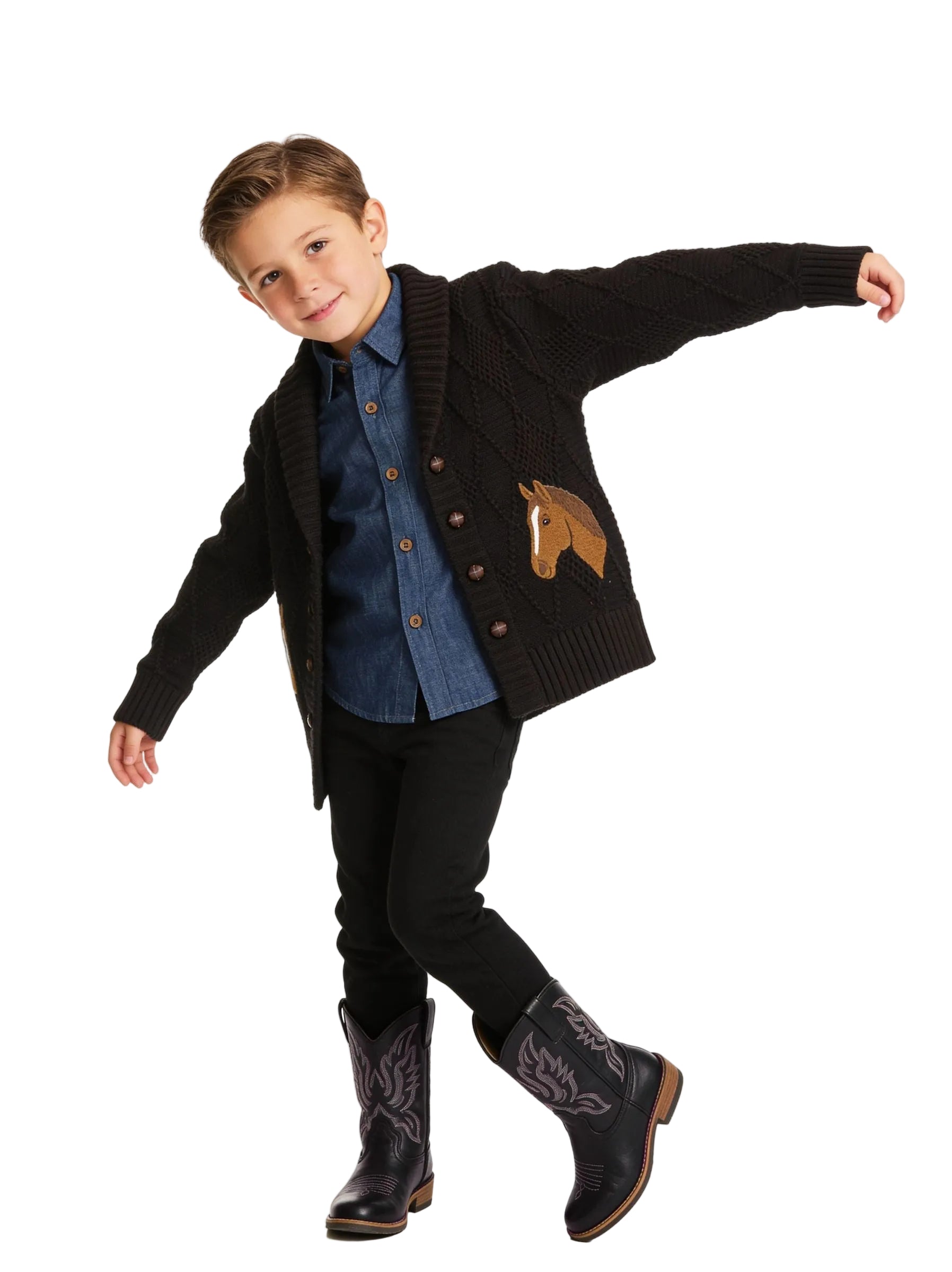 A young boy modeling a dark brown knit cardigan with a horse patch, worn over a blue denim shirt and black pants, against a textured cream background.