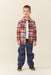 Young boy wearing a brown and multicolor plaid button down shirt with dark blue pants and brown shoes in a studio setting from Pink Chicken