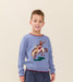 Young boy wearing a blue Pink Chicken sweater featuring a cowboy riding a bucking horse motif with red trim and dark pants