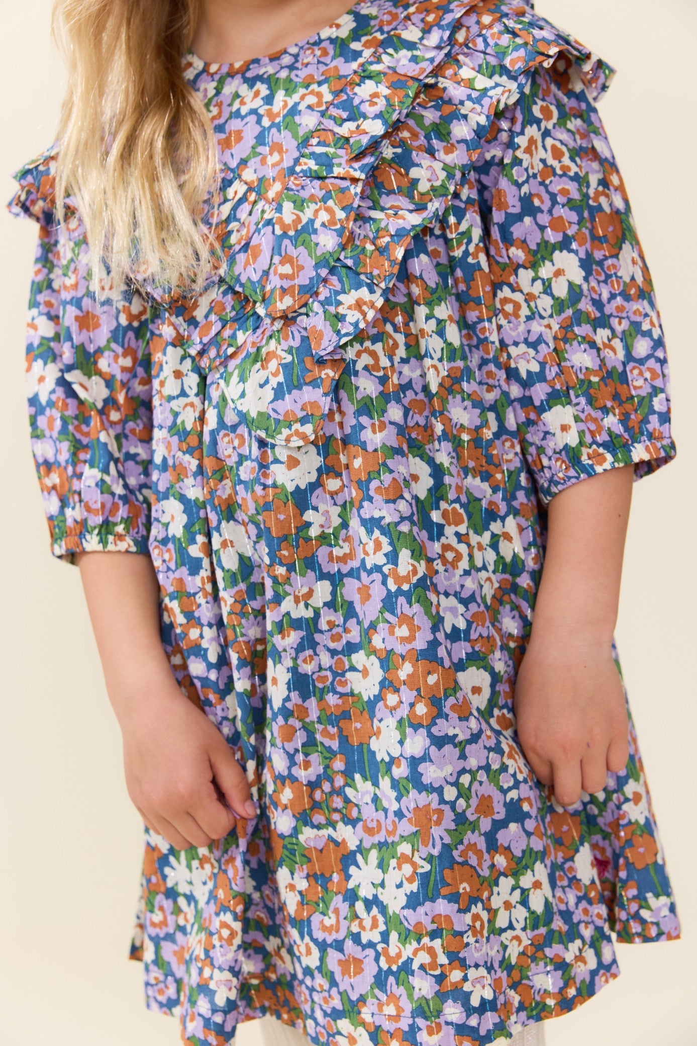 Pink Chicken girls blue floral dress with ruffled collar short sleeves and a gathered skirt modeled by a child