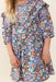 Pink Chicken girls blue floral dress with ruffled collar short sleeves and a gathered skirt modeled by a child