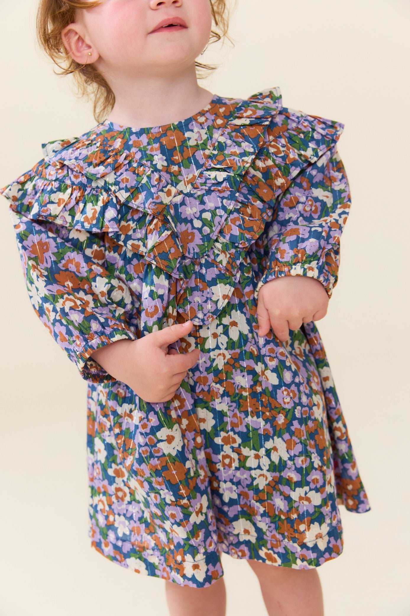 Young girl wearing a blue floral dress with a ruffled collar and puff sleeves from Pink Chicken for stylish everyday occasions
