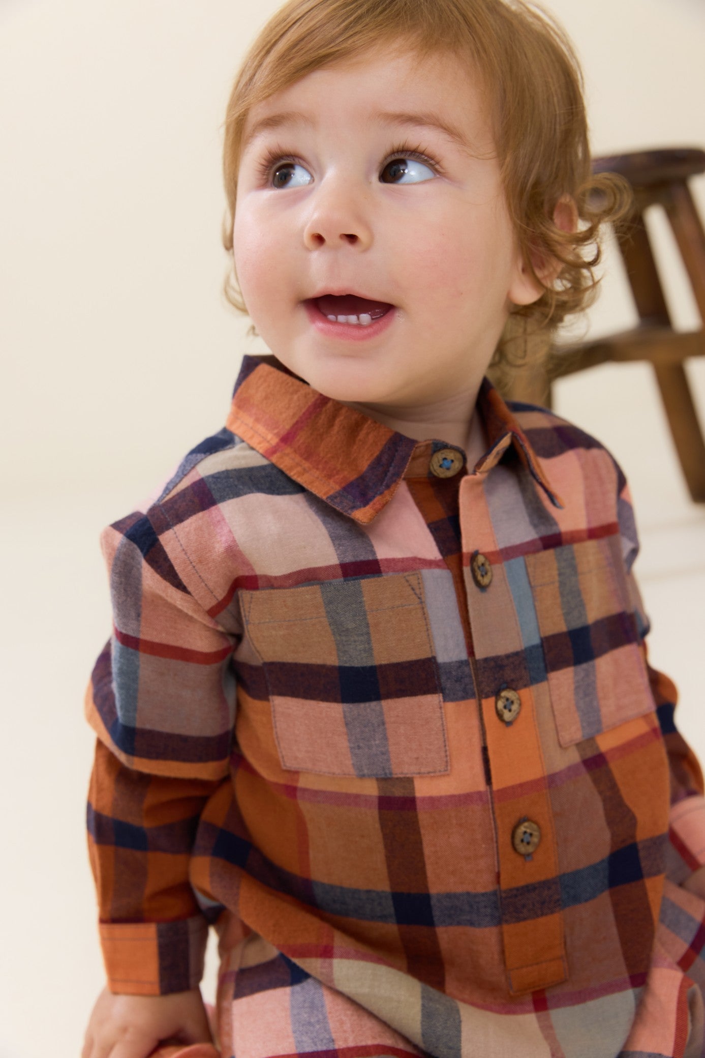 Toddler wearing a brown and rust plaid Easton jumper with button front and chest pockets by Pink Chicken