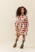 Pink Chicken girls dress in a pink and cream heart print with three quarter sleeves modeled by a child with curly hair and boots