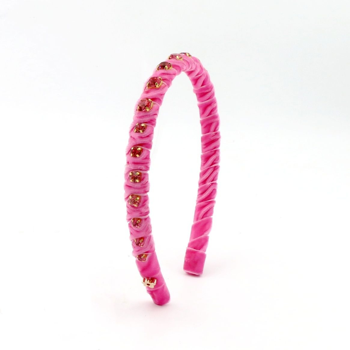 Pink headband with gold accents on a white background