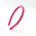 Pink headband with gold heart shapes on a white background