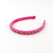 A pink velvet headband with a textured, ruched design and small gold rhinestone accents, displayed on a clean white background.
