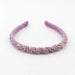 A lavender purple fabric headband with ruched rosettes and small gold-rimmed clear rhinestones, displayed on a clean white background.