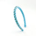 A light blue velvet headband decorated with small gold and green rhinestone clusters, shown on a plain white background.