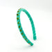 A turquoise velvet headband with twisted detailing and small green rhinestone embellishments, shown on a plain white background.