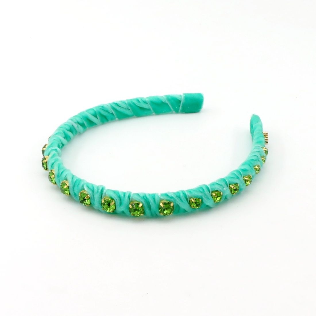 A turquoise braided headband embellished with small green rhinestones, displayed on a clean white background.
