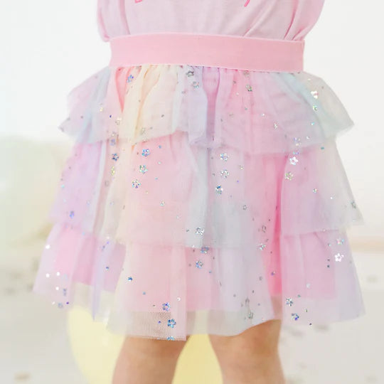 Pastel-colored dress with a glittery skirt on a white background