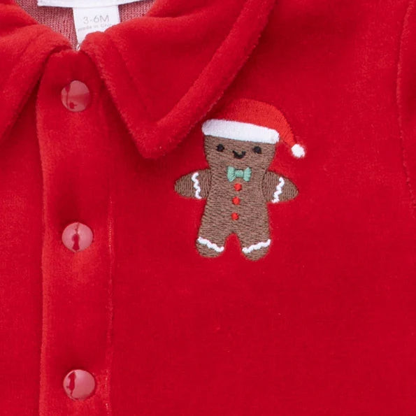 Red jumpsuit with a gingerbread man patch on a red background